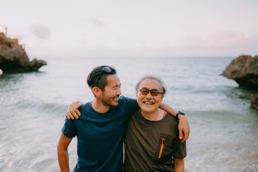 Father and son standing by the ocean.