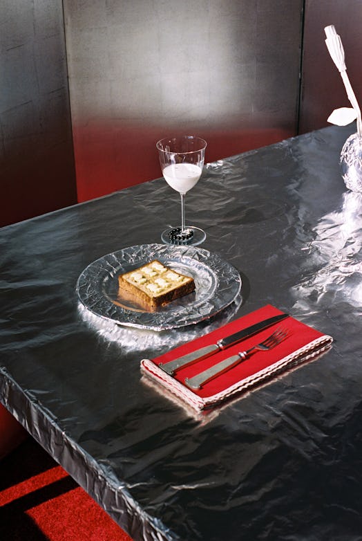 A piece of toast and a red napkin on a table covered in tin foil