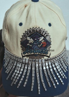 A necklace around a baseball cap