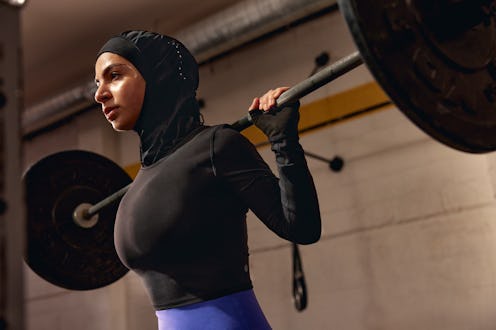 a model lifting weights in a lululemon performance hijab