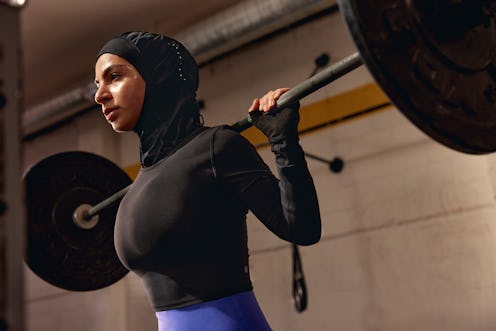 a model lifting weights in a lululemon performance hijab