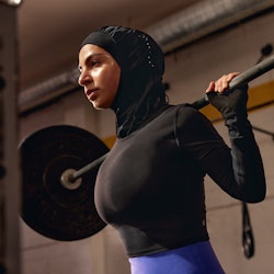 a model lifting weights in a lululemon performance hijab