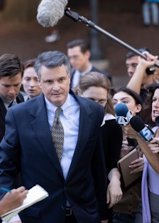 Colin Firth as Michael Peterson surrounded by reporters