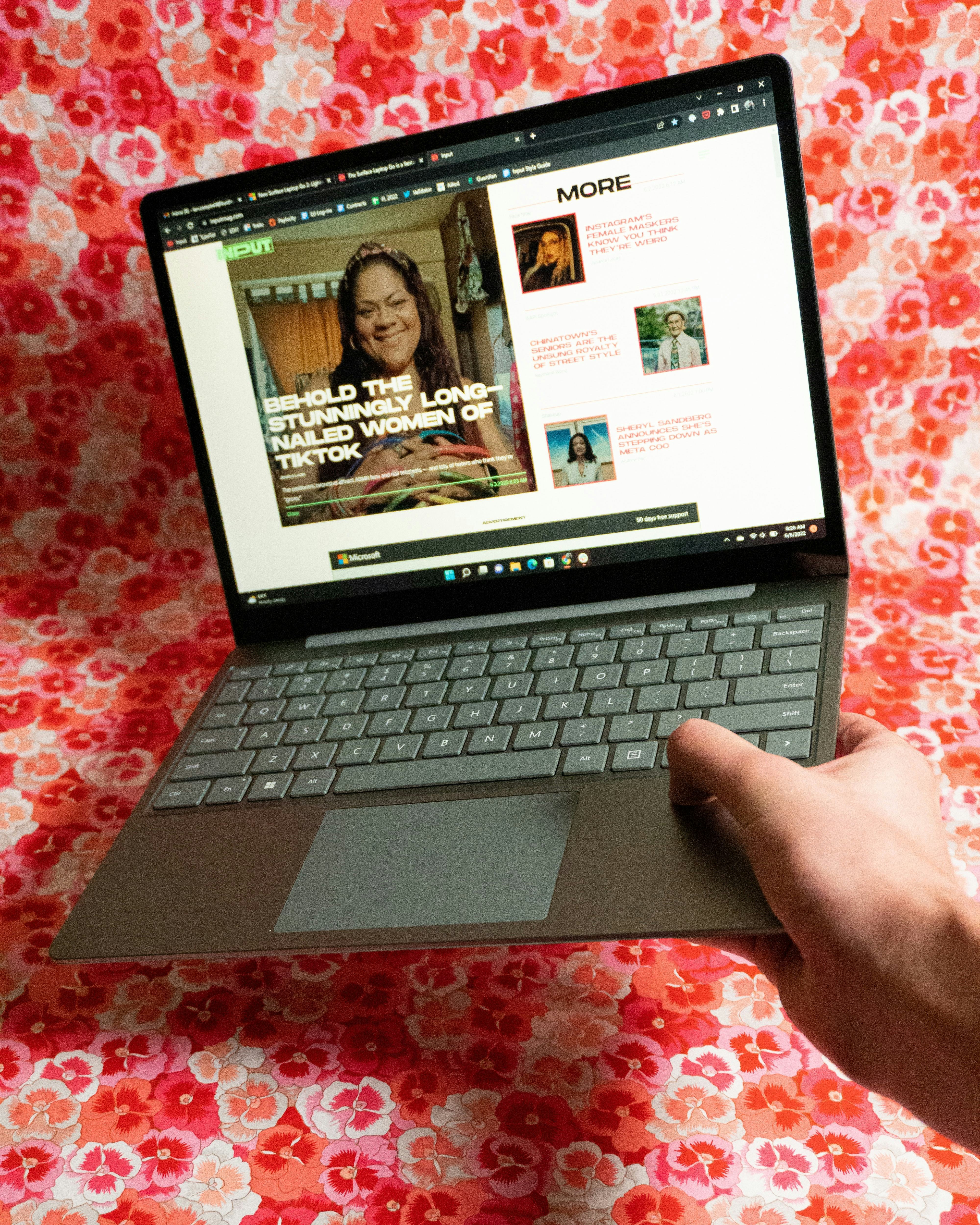 The Surface Laptop Go 2 held open in one hand.