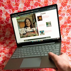 The Surface Laptop Go 2 held open in one hand.