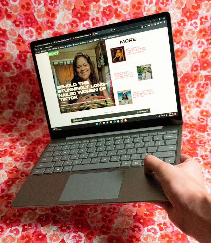 The Surface Laptop Go 2 held open in one hand.