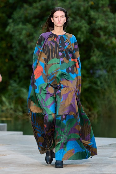 A female model walking in a colorful floral Max Mara dress
