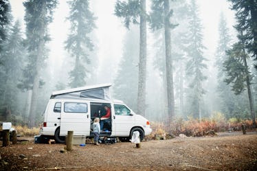 Father and daughter in camper van in forest