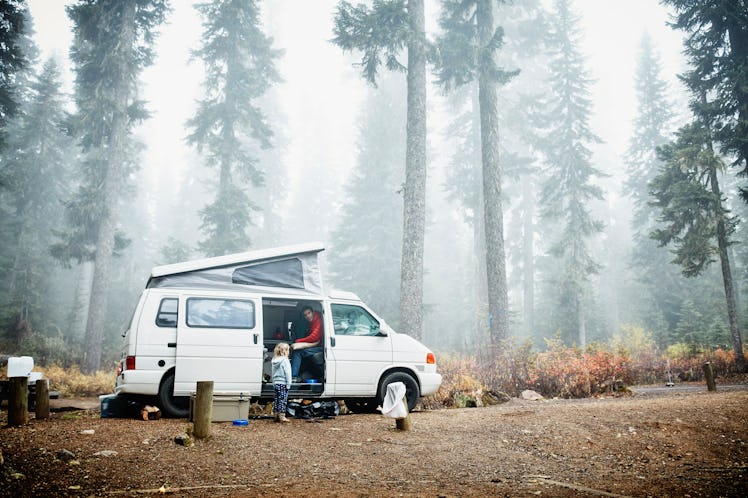 Father and daughter in camper van in forest