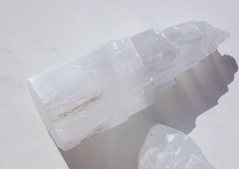 Selenite tower, a crystal for empaths, on a white background