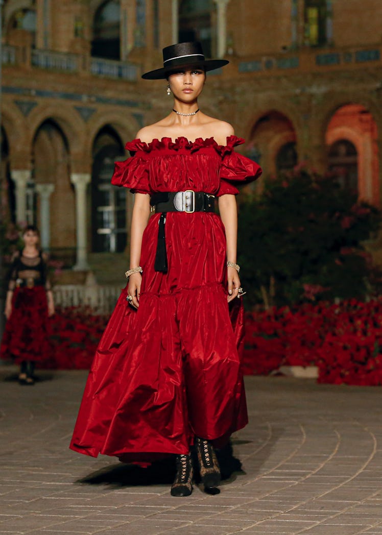 A female model walking in a red Dior dress
