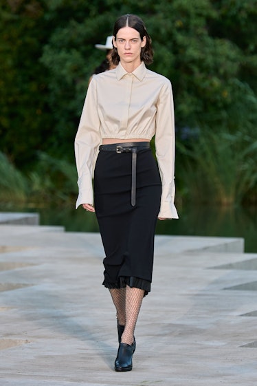 A female model in a white shirt and black skirt by Max Mara