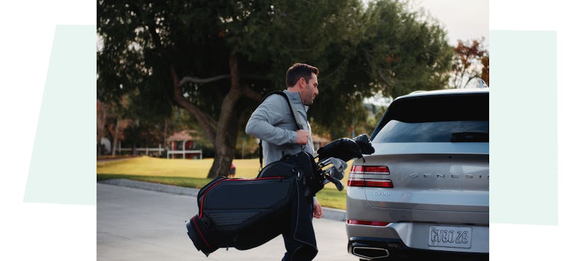 Andre Lacey carrying his golf bag to his Genisis Car.