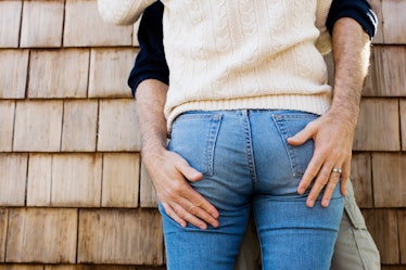 A man touching his partner's butt.