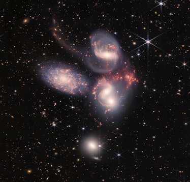 Stephan’s Quintet, seen by JWST through near- and mid-infrared wavelengths. Five galaxies swirl near...