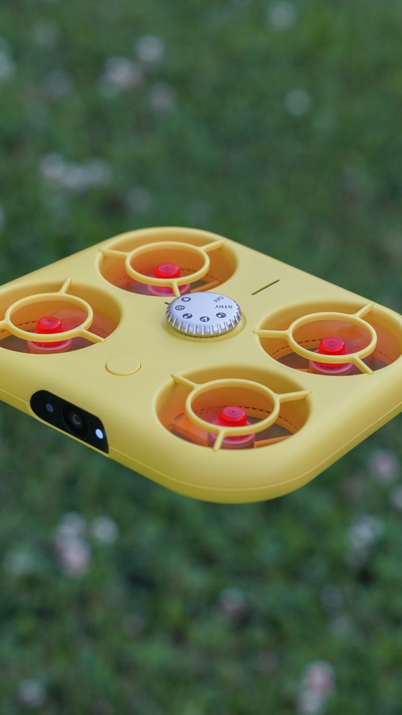 The Snap Pixy Drone mid-flight over grass.