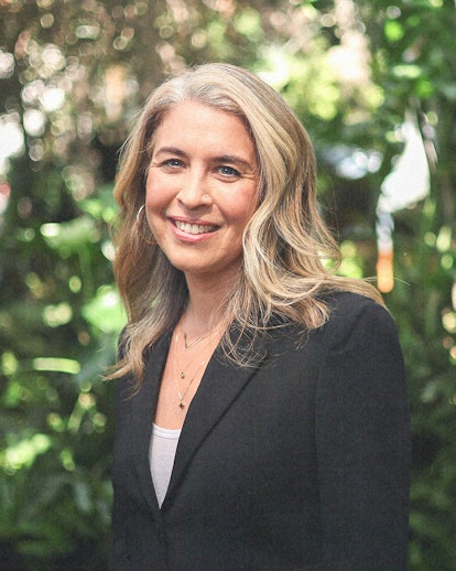 A portrait of Director Olivia Newman in front of green foliage