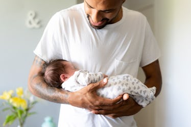 A dad holds his sleeping newborn.