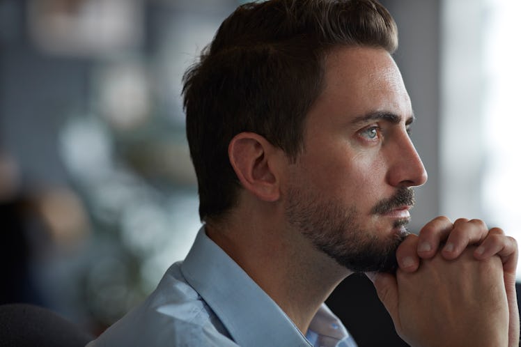 A man with a big nose resting his head on his hands.