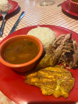 A plate of pork, rice, beans, and fried plantain as one of the specialties at San Juan