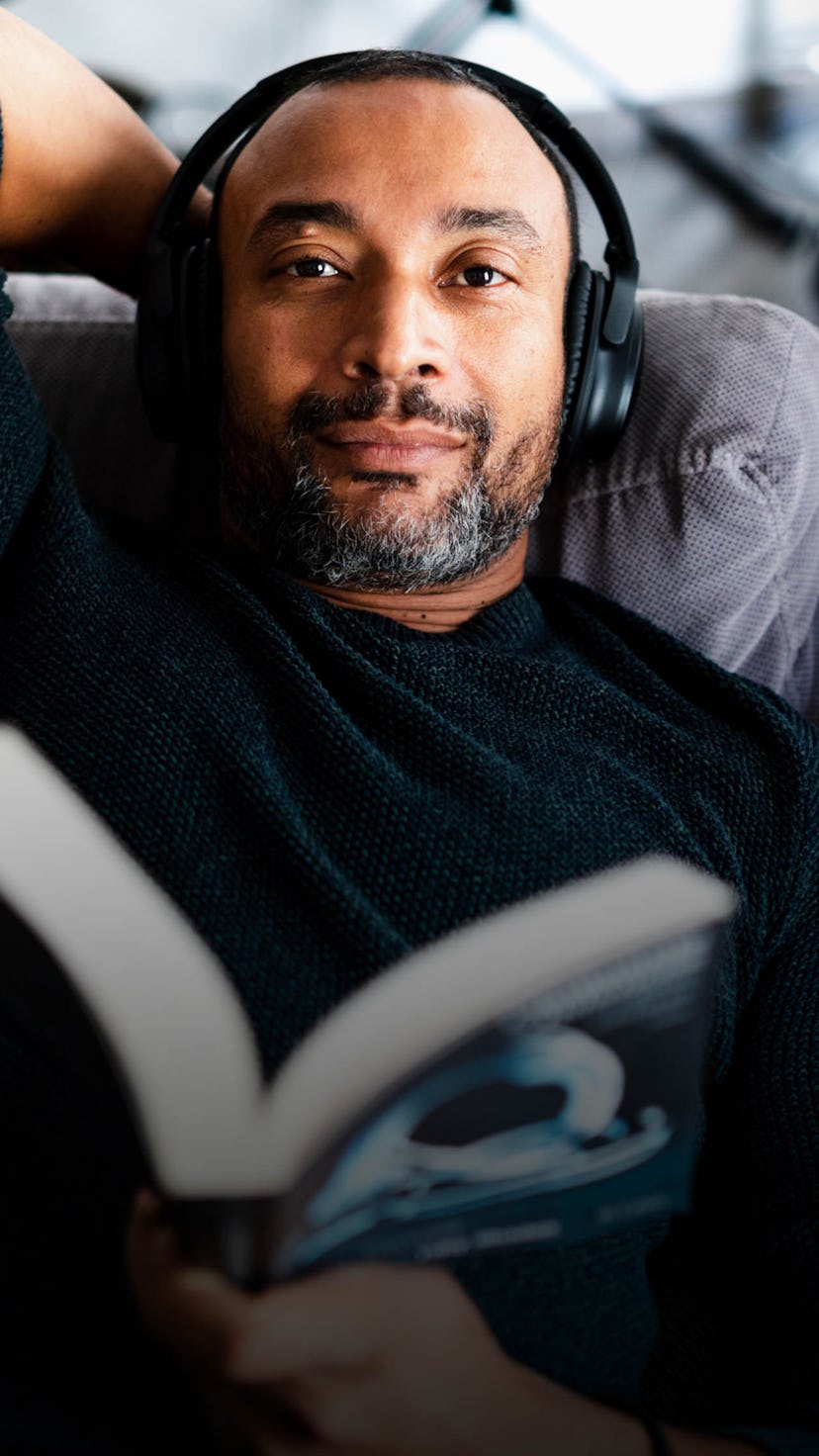 A middle-aged man lying and listening to music on his headphones