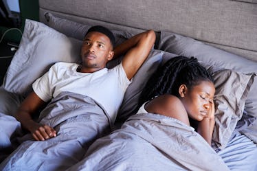 A may lying in bed awake while his wife sleeps beside him.