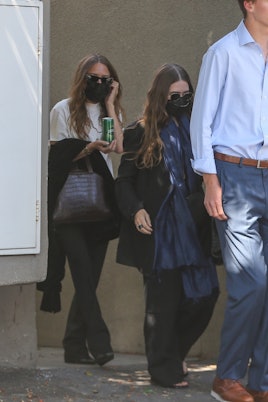 Mary-Kate and Ashley Olsen are escorted to their car after some shopping on trendy Melrose Place in ...
