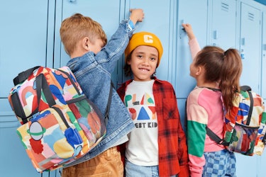 Two boys and a girl standing next to school lockers
