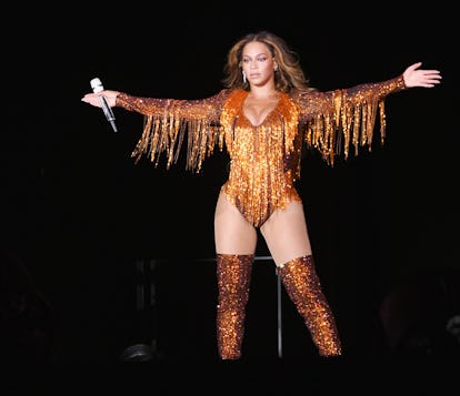 Beyonce in glittery orange body suit.