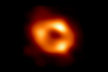 orange circle with clumps of brighter light with a dark area in the center