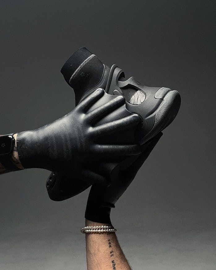 Two gloved hands holding Mr. Bailey and Adidas's OZLUCENT sneaker boot