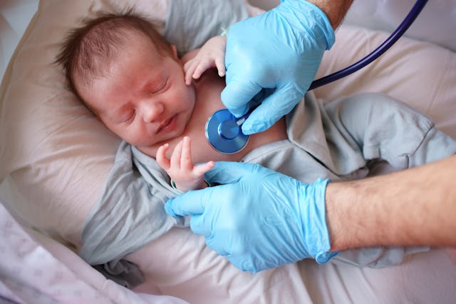 A doctor listens to an infant's breathing with a stethoscope.