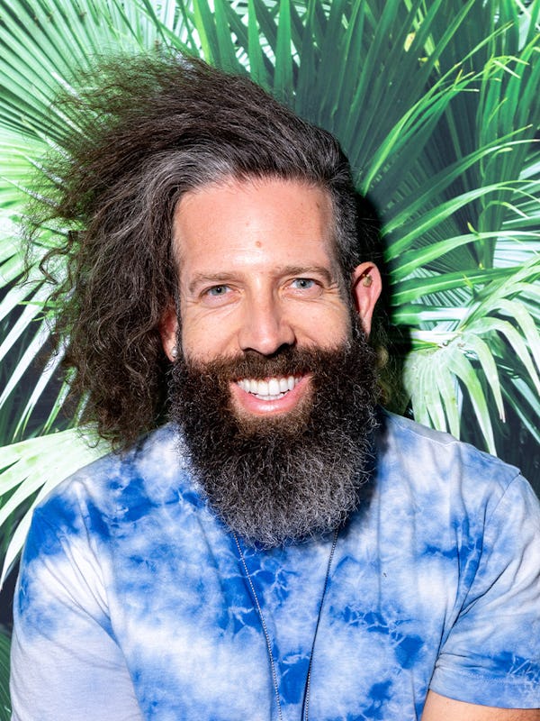 Elan Gale posing in front of a palm tree