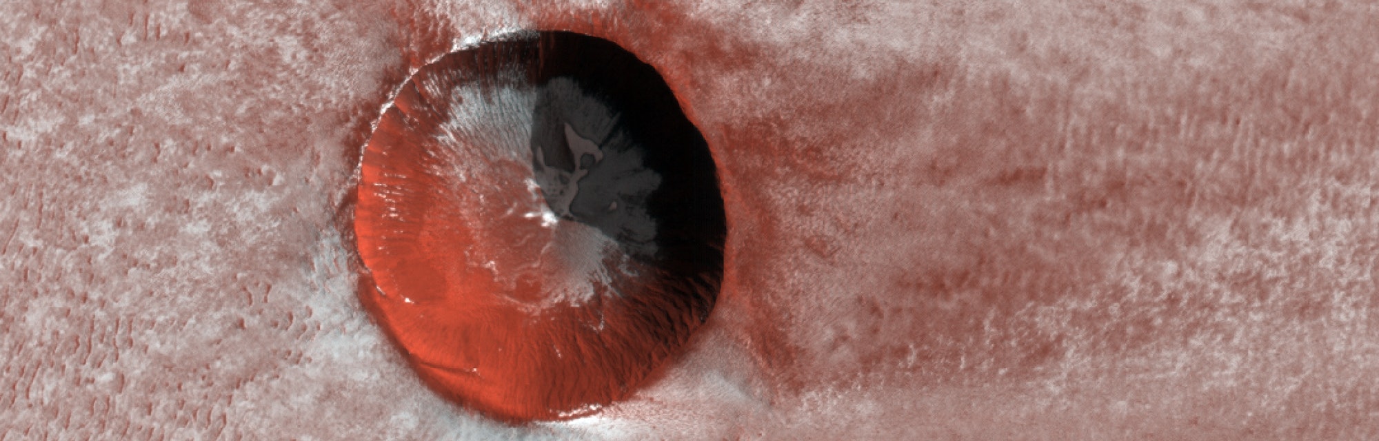 NASA's Mars Reconnaissance Orbiter imaged this relatively young, ice-filled crater near the north po...