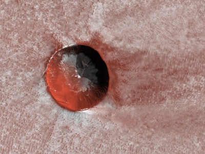 NASA's Mars Reconnaissance Orbiter imaged this relatively young, ice-filled crater near the north po...