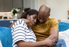 一个男人在妻子流产后安慰她，把她抱在沙发上。
