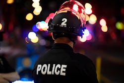 Denver police officers stand outside of McGregor Square to keep people moving down the street as fan...