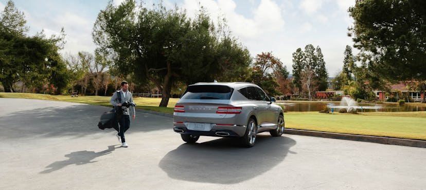 Andre Lacey carrying his golf bag to his Genisis Car.