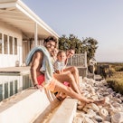 Family sitting near summer vacation house
