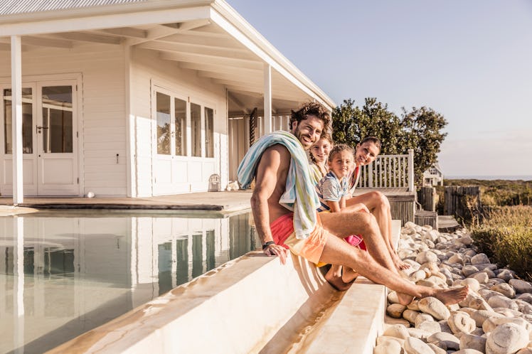 Family sitting near summer vacation house