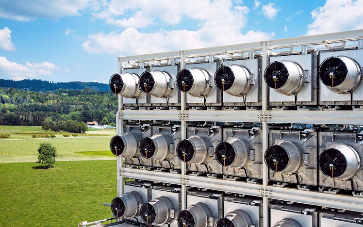 A large array of industrial-sized fans in a countryside field