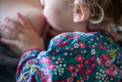 A mother breastfeeds her toddler. The new AAP guidelines recommend breastfeeding for at least two ye...