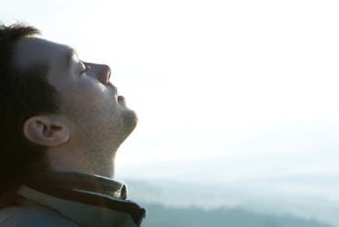 A man practicing lamaze breathing outdoors.