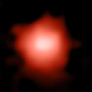 Color image of a blurry orange-white galaxy in space