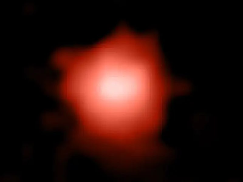 Color image of a blurry orange-white galaxy in space