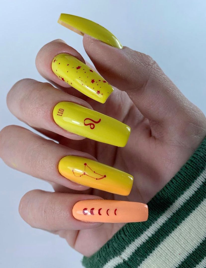 A bold and beautiful Leo birthday nail design with an orange and yellow gradient across fingers