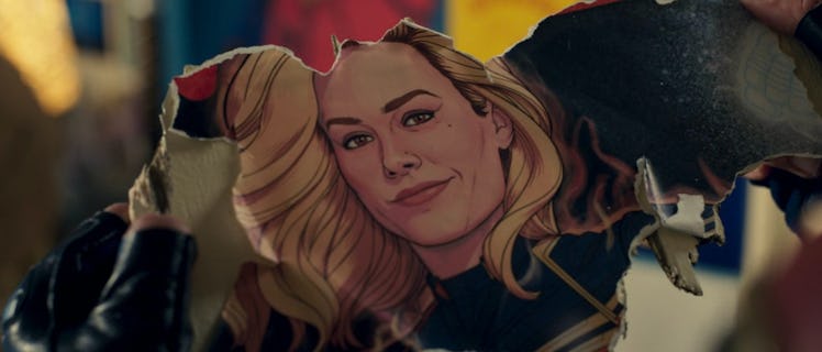 Carol Danvers (Brie Larson) looks at piece of promotional art of herself in the Ms. Marvel post-cred...