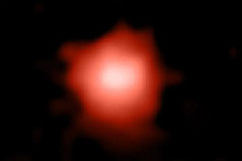 Color image of a blurry orange-white galaxy in space