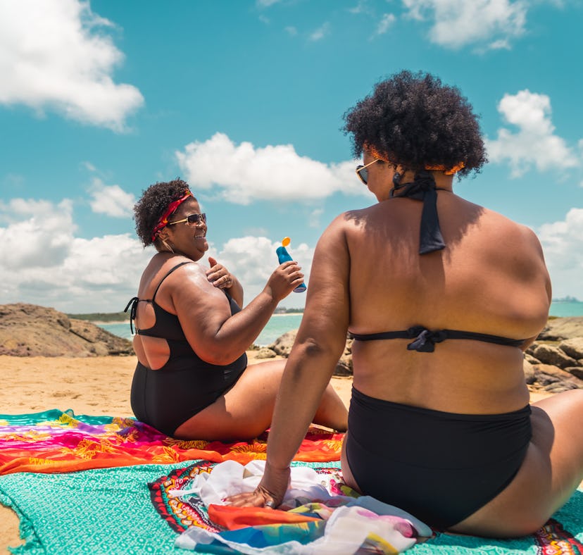Two young friends having fun on the beach after reading their July 25, 2022 weekly horoscope.