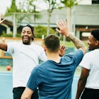 A group of men high-fiving each other after a game of dodgeball.